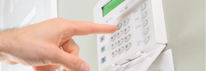 Eine Person gibt einen Code in eine Alarmanlage ein.